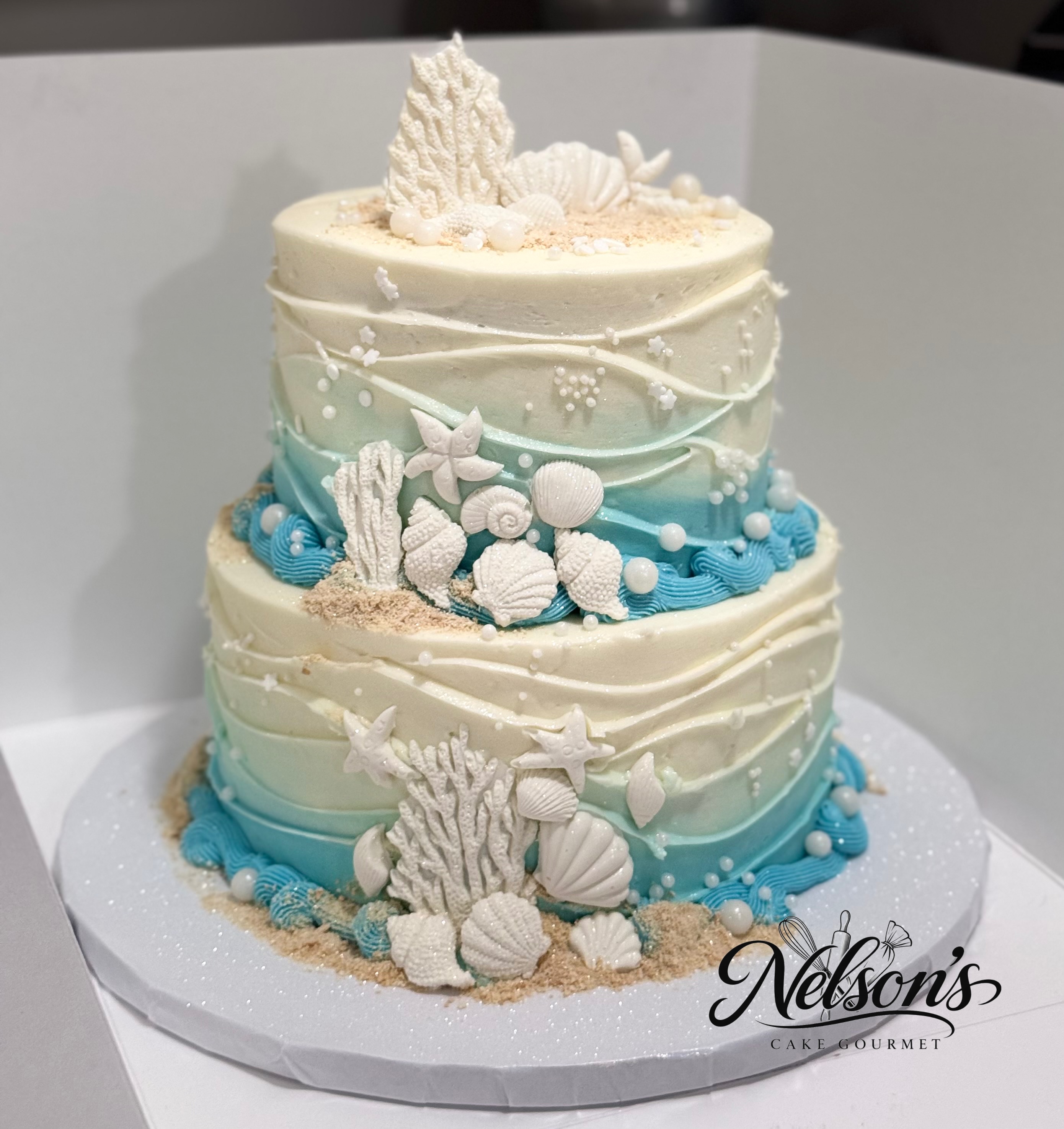 Two-tier ocean-inspired cake with seashell decorations